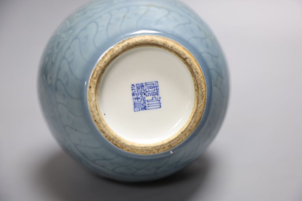 A Chinese bottle vase with carved detail under a pale blue glaze, height 22cm